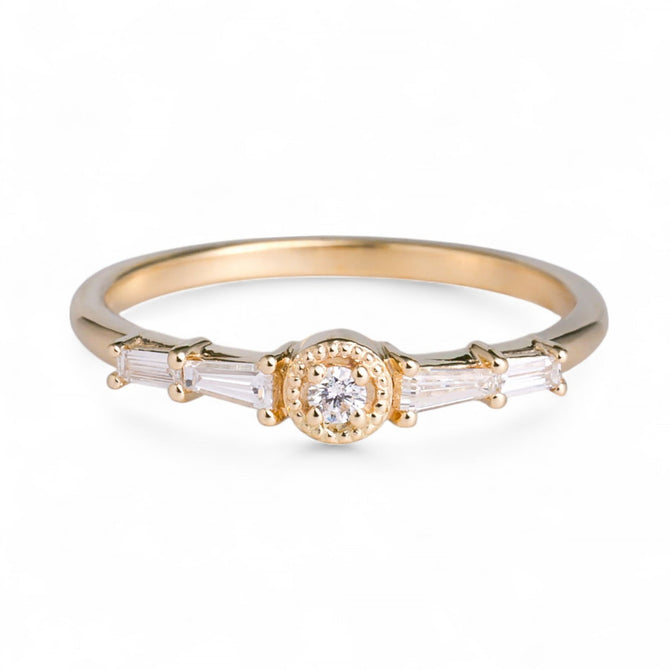 Gold ring with a central diamond and baguette-cut stones on a white background